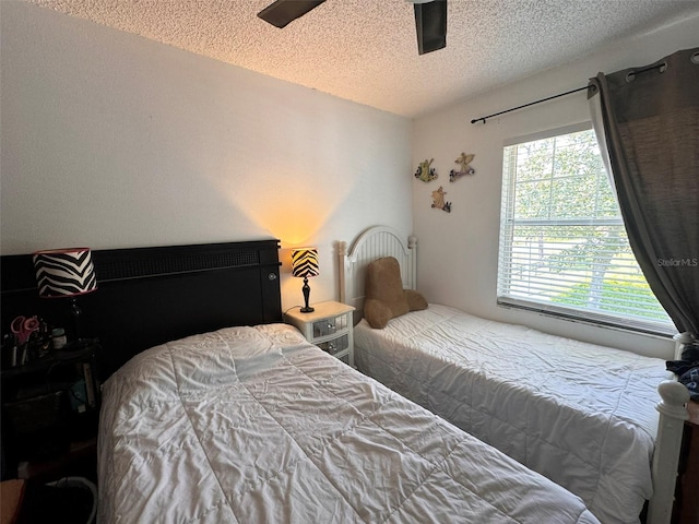 bedroom with a textured ceiling and ceiling fan