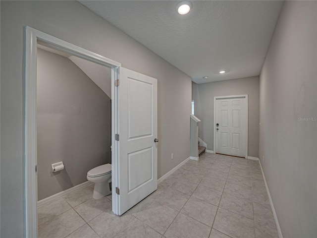 bathroom with toilet, tile patterned floors, and a textured ceiling