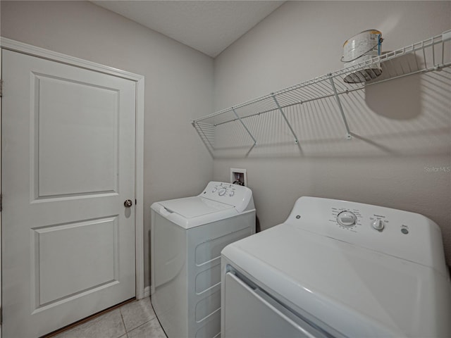 washroom with light tile patterned floors and washing machine and dryer