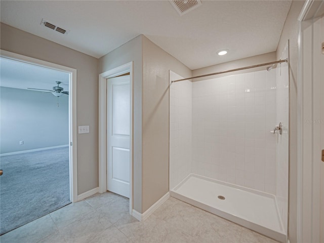 bathroom featuring ceiling fan and a tile shower