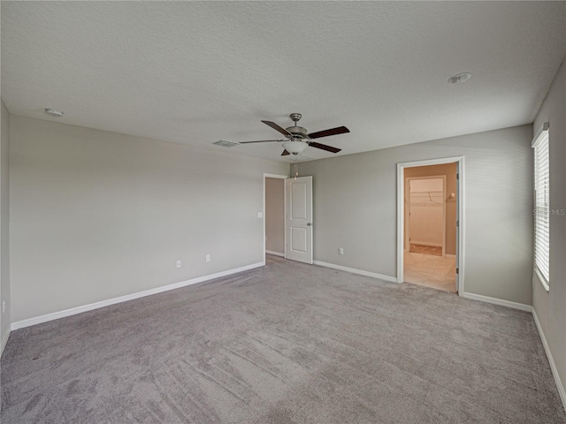 carpeted empty room featuring ceiling fan and a textured ceiling