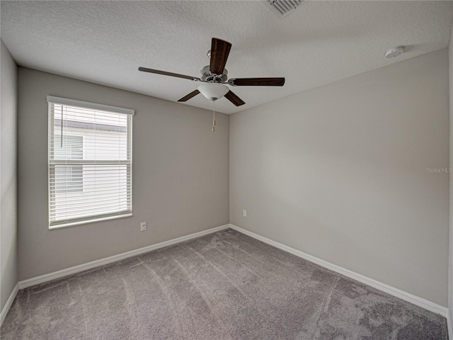 carpeted spare room featuring ceiling fan and a textured ceiling