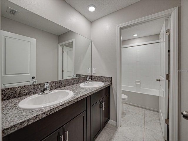 full bathroom with a textured ceiling, shower / bathing tub combination, tile patterned floors, vanity, and toilet