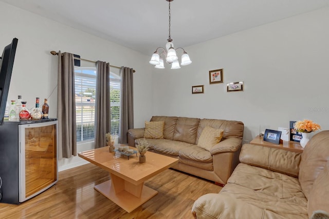 living room with bar area, wine cooler, a chandelier, and hardwood / wood-style flooring