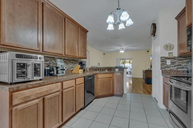 kitchen featuring ceiling fan with notable chandelier, stainless steel appliances, light hardwood / wood-style floors, pendant lighting, and decorative backsplash