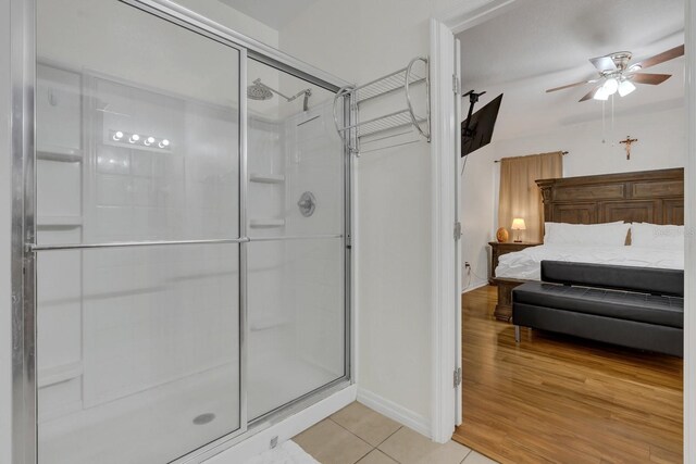 bathroom with ceiling fan, hardwood / wood-style flooring, and walk in shower