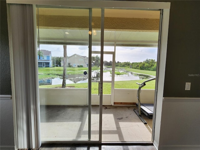 doorway to outside with a healthy amount of sunlight, light hardwood / wood-style flooring, and a water view