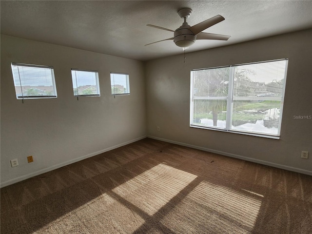 unfurnished room featuring a textured ceiling, ceiling fan, and dark colored carpet