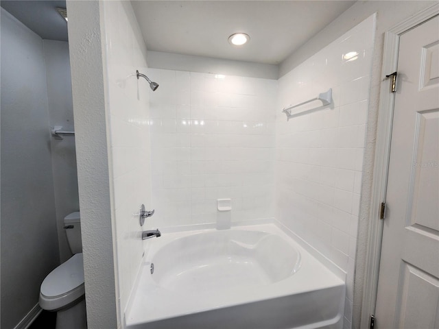 bathroom with toilet and tiled shower / bath combo