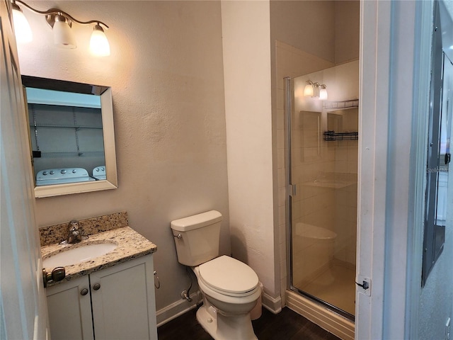 bathroom featuring vanity, toilet, wood-type flooring, and a shower with door