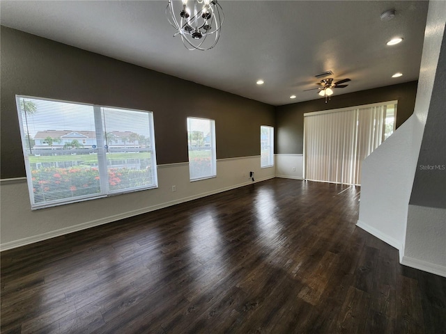 unfurnished living room with dark wood-type flooring and ceiling fan with notable chandelier