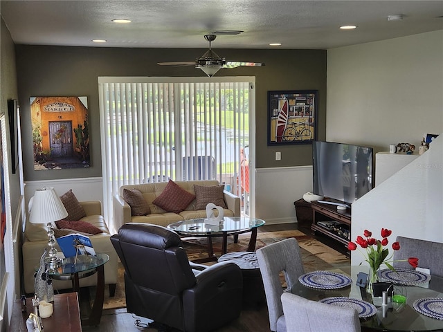 living room featuring a textured ceiling, ceiling fan, and wood-type flooring