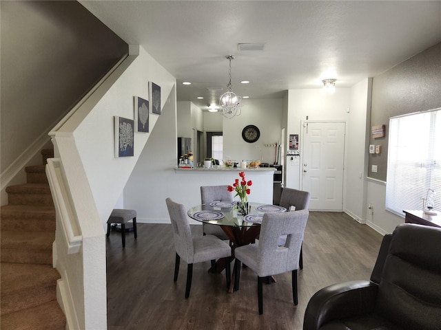 dining area with hardwood / wood-style floors and a notable chandelier