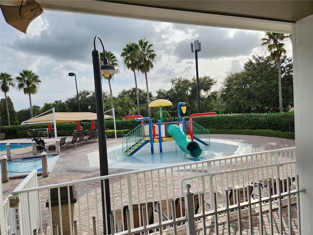 view of jungle gym featuring a community pool and a patio