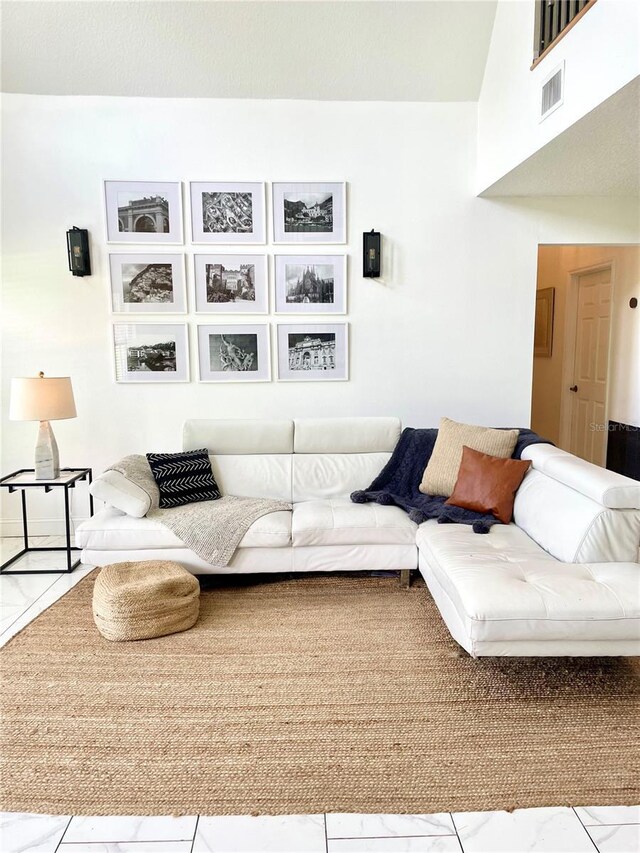 living area featuring marble finish floor and visible vents