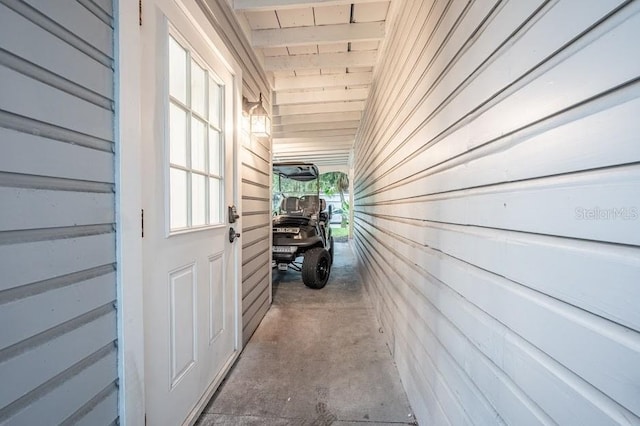 hallway with wooden walls and concrete floors