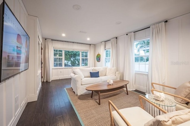 living room featuring dark hardwood / wood-style flooring and a healthy amount of sunlight