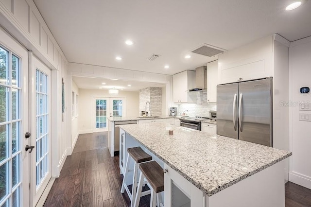 kitchen featuring dark hardwood / wood-style flooring, french doors, stainless steel appliances, sink, and kitchen peninsula