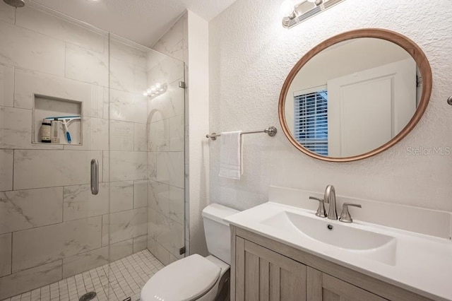 bathroom featuring vanity, toilet, and a shower with shower door