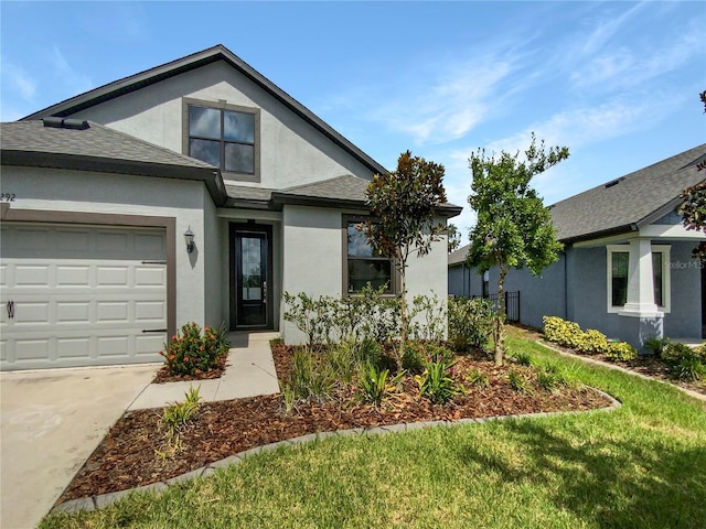 view of front of home with an attached garage, roof with shingles, and stucco siding