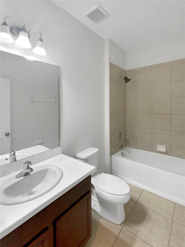 full bathroom with tiled shower / bath combo, vanity, toilet, and tile patterned flooring