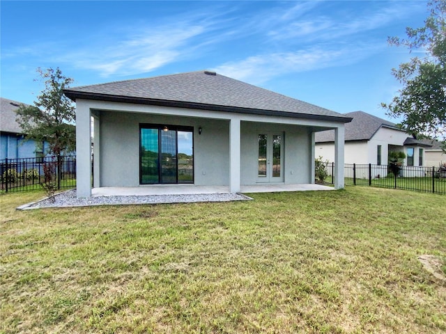 back of property featuring french doors, a patio area, and a lawn