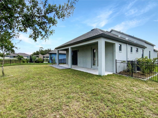 back of property featuring a lawn and a patio