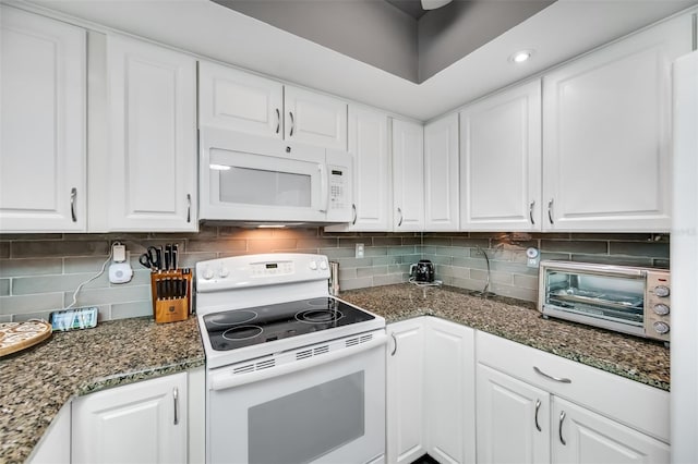 kitchen with white cabinetry, white appliances, dark stone countertops, and tasteful backsplash