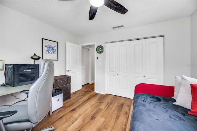 office area with ceiling fan, a textured ceiling, and hardwood / wood-style floors