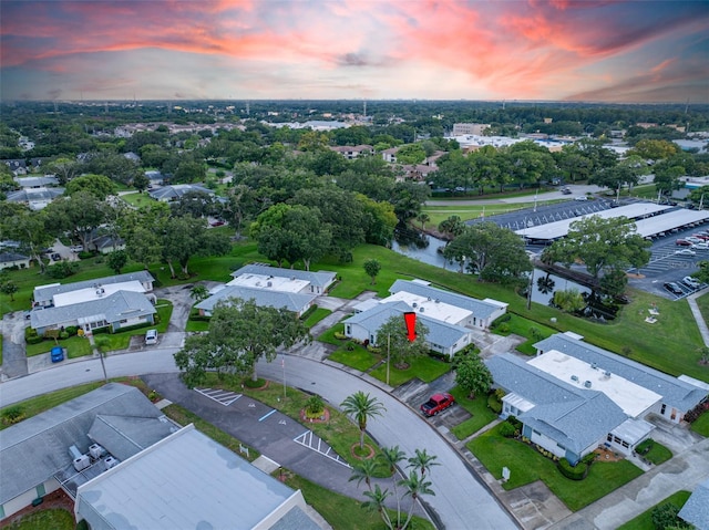 aerial view at dusk featuring a water view