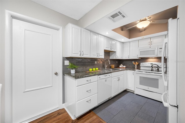 kitchen featuring visible vents, white cabinets, white appliances, and a sink