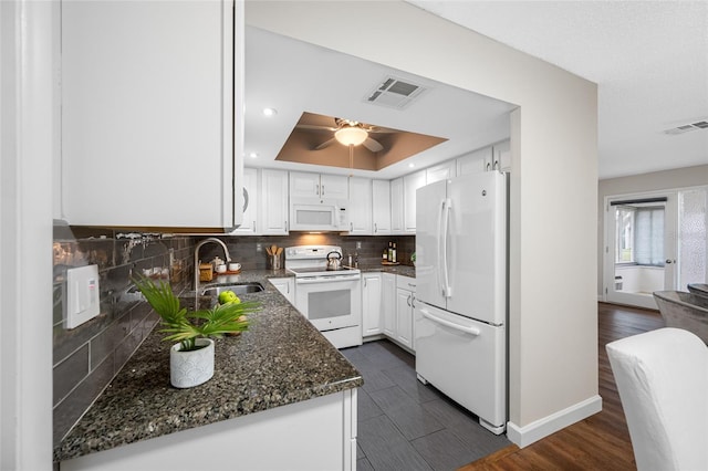 kitchen with tasteful backsplash, visible vents, white appliances, and a sink