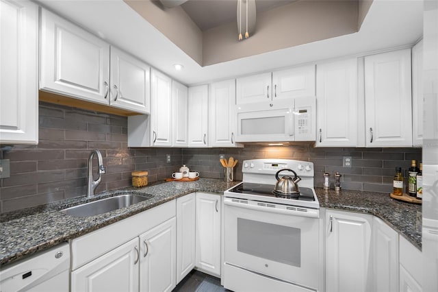 kitchen with decorative backsplash, white appliances, white cabinetry, and a sink