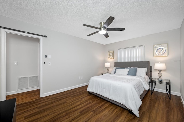 bedroom featuring visible vents, a textured ceiling, wood finished floors, baseboards, and ceiling fan