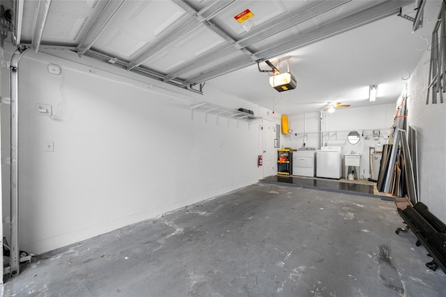 garage with a sink, a garage door opener, and separate washer and dryer