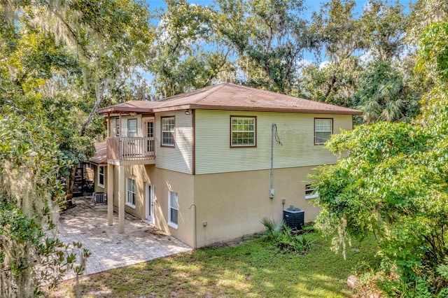 rear view of property featuring central AC unit and a patio area