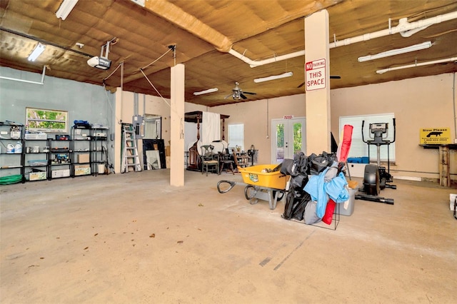 garage featuring a garage door opener, ceiling fan, and wood ceiling