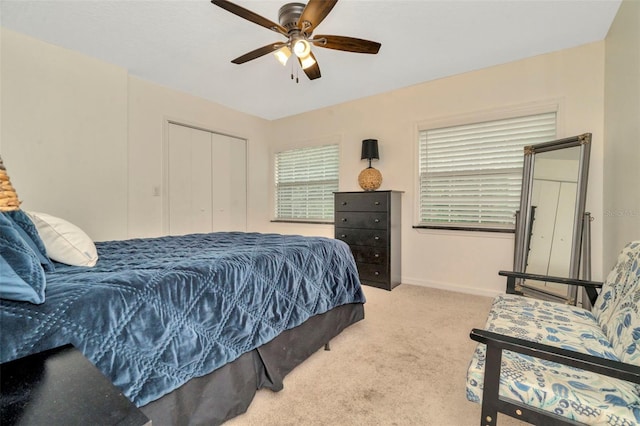 carpeted bedroom with ceiling fan and a closet