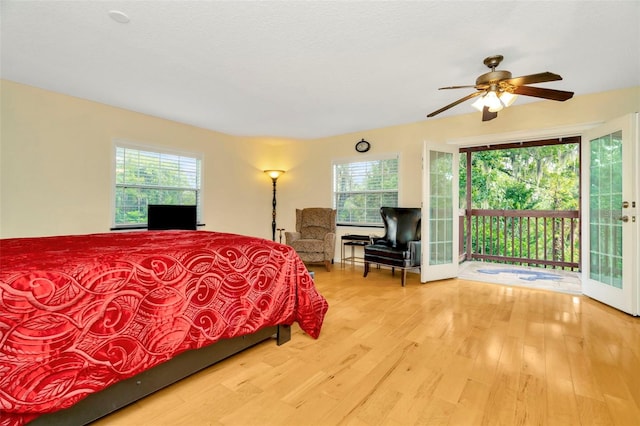 bedroom with multiple windows, access to outside, french doors, and light hardwood / wood-style floors