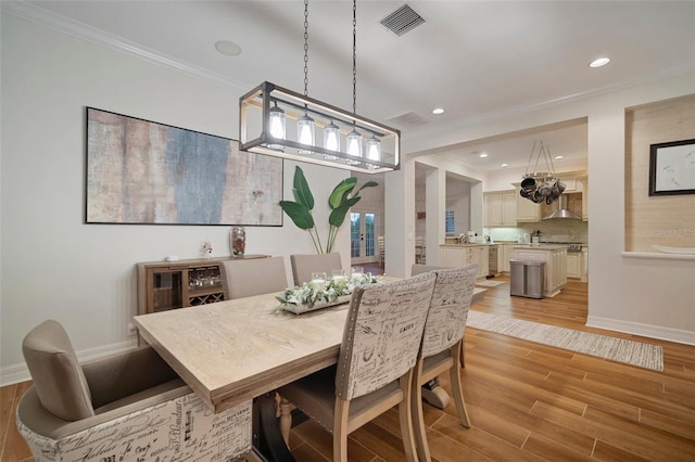 825 Islebay Dr, Apollo Beach, FL 33572 - dining area with crown molding, recessed lighting, light wood-type flooring, baseboards, and visible vents