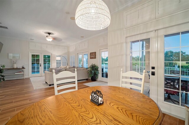 825 Islebay Dr, Apollo Beach, FL 33572 - dining space with wood finished floors, ornamental molding, french doors, and an inviting chandelier