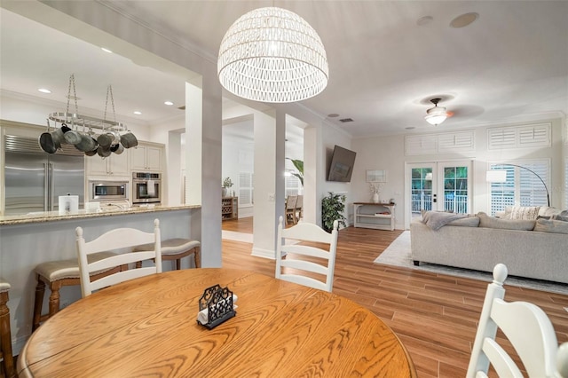 825 Islebay Dr, Apollo Beach, FL 33572 - dining area featuring french doors, crown molding, light wood finished floors, and recessed lighting