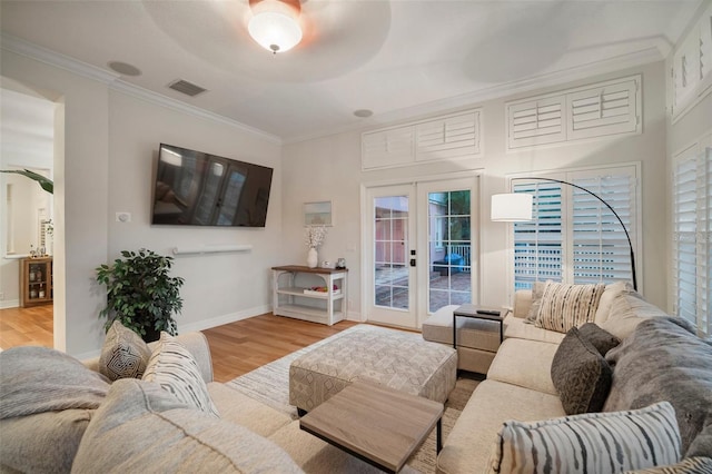 living room featuring crown molding, french doors, and light hardwood / wood-style floors