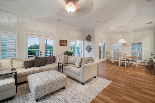 living room with ceiling fan, ornamental molding, hardwood / wood-style floors, and french doors