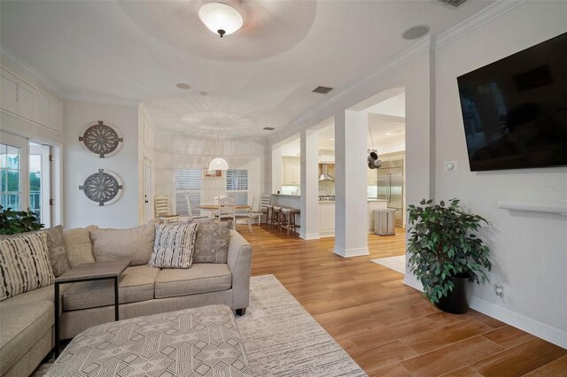 825 Islebay Dr, Apollo Beach, FL 33572 - living room featuring baseboards, light wood-type flooring, visible vents, and ornamental molding