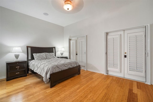 bedroom featuring multiple closets, ceiling fan, and light hardwood / wood-style floors