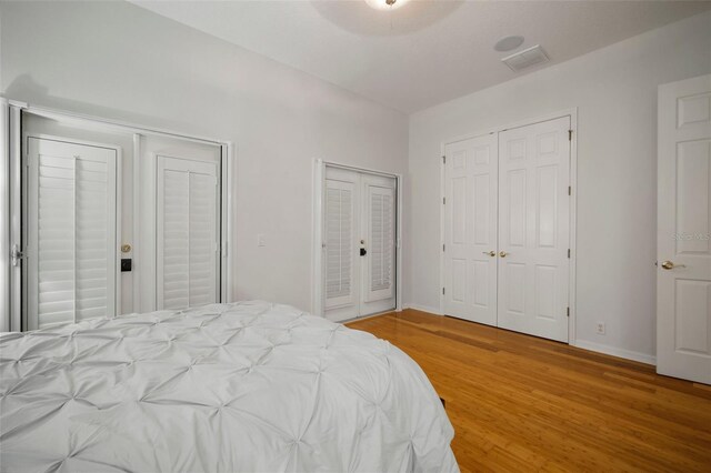 825 Islebay Dr, Apollo Beach, FL 33572 - bedroom featuring baseboards, multiple closets, ensuite bath, visible vents, and light wood-style flooring