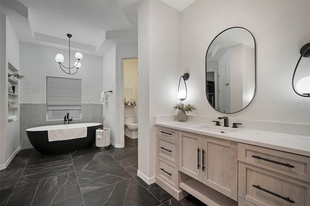 825 Islebay Dr, Apollo Beach, FL 33572 - bathroom with a freestanding tub, toilet, vanity, marble finish floor, and an inviting chandelier