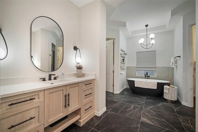 825 Islebay Dr, Apollo Beach, FL 33572 - full bathroom featuring vanity, a raised ceiling, a soaking tub, marble finish floor, and baseboards