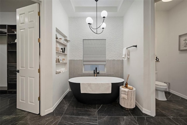 bathroom featuring tile walls, a bathtub, toilet, and a raised ceiling